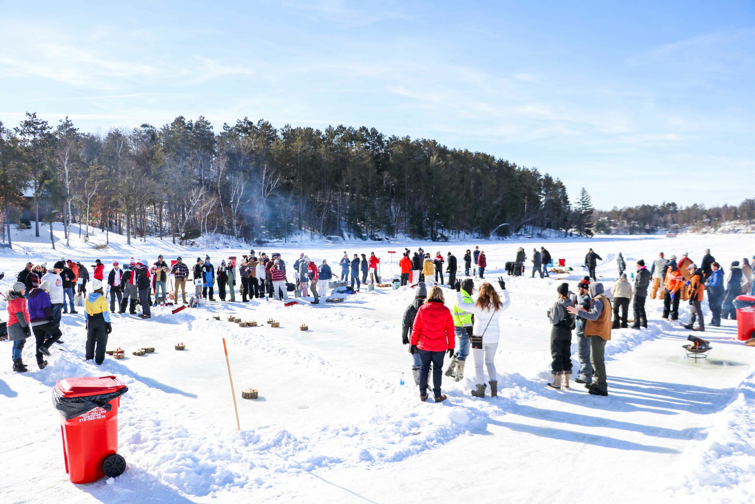 People crowded on ice of a frozen lake playing bobber bocce on ice